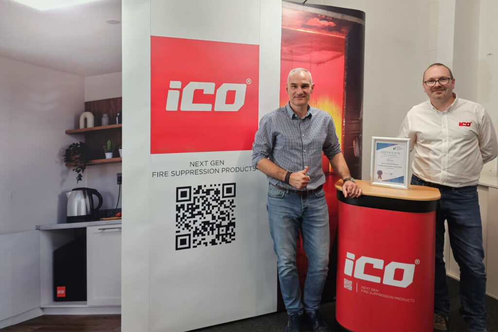 iCO exhibition team stand in front of display